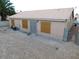 Exterior view of the backyard with tile roof, boarded windows, and security door at 4225 Seth Dr, North Las Vegas, NV 89032