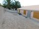 Exterior backyard view with tiled roof, palm trees, boarded windows, and cement block wall at 4225 Seth Dr, North Las Vegas, NV 89032