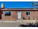 View of front exterior of home featuring brick facade, white door, and low water landscape at 4424 Shady Hollow Ave, North Las Vegas, NV 89031