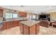 Spacious kitchen with granite island, tile backsplash, stainless steel sink, and seamless flow to the living area at 4424 Shady Hollow Ave, North Las Vegas, NV 89031