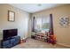 bedroom with TV, toy storage, and window coverings at 4495 Violet Flowers St # 2046, North Las Vegas, NV 89031