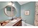 Stylish bathroom featuring a round mirror and a granite countertop sink at 4499 Amazing View St, Las Vegas, NV 89129