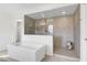 Modern bathroom featuring a soaking tub and a tiled walk-in shower with glass partition at 4499 Amazing View St, Las Vegas, NV 89129