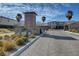 Gated community entrance with lush landscaping, a decorative sign, and a view of the surrounding mountains at 4499 Amazing View St, Las Vegas, NV 89129