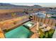 Aerial view of an incredible backyard with pool, spa, lounge area, and desert landscaping at twilight at 4499 Amazing View St, Las Vegas, NV 89129