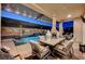 Outdoor dining area with a pergola, overlooking a stunning pool and lush backyard landscaping at 4499 Amazing View St, Las Vegas, NV 89129