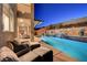 Relaxing poolside seating area with serene views of the pool, waterfall, and landscaping at 4499 Amazing View St, Las Vegas, NV 89129