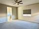 Spacious bedroom with ceiling fan, large window, and plush carpeting at 5249 Fiery Sky Ridge St, Las Vegas, NV 89148