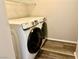 Well-lit laundry room, complete with washer and dryer, and overhead shelving at 5249 Fiery Sky Ridge St, Las Vegas, NV 89148