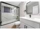 Modern bathroom with white vanity, marble shower, and black accents at 5509 Evergreen Ave, Las Vegas, NV 89107