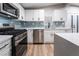 Updated kitchen featuring white cabinets, stainless steel appliances, and light blue tile backsplash at 5509 Evergreen Ave, Las Vegas, NV 89107