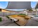 Modern backyard pool deck with built-in seating and shade sail at 5509 Evergreen Ave, Las Vegas, NV 89107