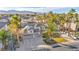 Aerial view of a luxury home with a three car garage, solar panels, and surrounded by palm trees at 6005 Blowing Bellows St, Las Vegas, NV 89130