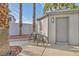 Backyard features a guest house and an outdoor dining set with palm tree landscaping at 6005 Blowing Bellows St, Las Vegas, NV 89130