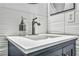 Close up of a bathroom vanity featuring a stainless steel faucet and white countertops in front of textured tile at 6005 Blowing Bellows St, Las Vegas, NV 89130