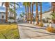 Long driveway leads to a secure gate, surrounded by lush landscaping and mature palm trees at 6005 Blowing Bellows St, Las Vegas, NV 89130