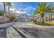 Charming single-story home featuring a three-car garage, desert landscaping and palm trees at 6005 Blowing Bellows St, Las Vegas, NV 89130