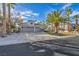 Charming single-story home featuring a three-car garage, desert landscaping and palm trees at 6005 Blowing Bellows St, Las Vegas, NV 89130