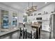 Bright kitchen with stainless steel appliances, modern light fixture, island, and pool view through french doors at 6005 Blowing Bellows St, Las Vegas, NV 89130