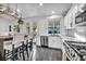 Well-lit kitchen features white cabinetry, stainless steel appliances, and modern lighting fixtures at 6005 Blowing Bellows St, Las Vegas, NV 89130