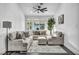 Cozy living room with a neutral color palette, plush furniture, large windows, and stylish ceiling fan at 6005 Blowing Bellows St, Las Vegas, NV 89130