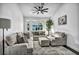 Inviting living room with a comfy seating arrangement, big windows, and modern ceiling fan at 6005 Blowing Bellows St, Las Vegas, NV 89130