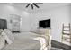 Bright main bedroom featuring a ceiling fan, hardwood floors, and an attached ensuite bathroom at 6005 Blowing Bellows St, Las Vegas, NV 89130