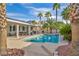 Backyard pool and patio area surrounded by lush palm trees for a tropical feel at 6005 Blowing Bellows St, Las Vegas, NV 89130