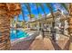 Beautiful backyard oasis featuring a sparkling pool, covered patio, and lush landscaping at 6005 Blowing Bellows St, Las Vegas, NV 89130