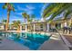 Gorgeous backyard featuring a shimmering pool, shaded patio, and tropical landscaping at 6005 Blowing Bellows St, Las Vegas, NV 89130