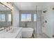 Well-lit bathroom featuring a sleek bathtub and a separate glass-enclosed shower with luxurious fixtures at 6027 Stone Hollow Ave, Las Vegas, NV 89156