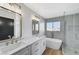 Modern bathroom with double sinks, quartz countertop, and a luxurious bathtub with shower at 6027 Stone Hollow Ave, Las Vegas, NV 89156