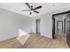 This bedroom features wood floors, a ceiling fan, and closet with sliding doors at 6027 Stone Hollow Ave, Las Vegas, NV 89156