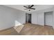 This bedroom features wood floors, a ceiling fan, and a double door closet at 6027 Stone Hollow Ave, Las Vegas, NV 89156