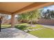 This outdoor view features a covered patio and manicured lawn at 6151 Moonlight Sonata Ave, Las Vegas, NV 89122