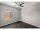 Bright bedroom with dark floors, a modern ceiling fan, and a large window allowing ample natural light at 6151 Moonlight Sonata Ave, Las Vegas, NV 89122