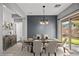 Staged dining room featuring a table setting for six and a sliding door to the backyard at 6151 Moonlight Sonata Ave, Las Vegas, NV 89122