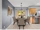 Staged dining room with table setting for six near the kitchen at 6151 Moonlight Sonata Ave, Las Vegas, NV 89122