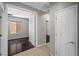 Bright hallway with neutral walls leading to a bedroom with sleek, dark wood flooring and natural light at 6151 Moonlight Sonata Ave, Las Vegas, NV 89122