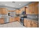 Kitchen featuring stainless steel appliances, wood cabinets, tile floors, and granite counters at 6151 Moonlight Sonata Ave, Las Vegas, NV 89122