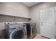 Modern laundry room with stainless steel washer and dryer, and neutral-tone walls at 6151 Moonlight Sonata Ave, Las Vegas, NV 89122