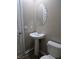 Small bathroom with pedestal sink, toilet, and oval mirror at 6460 Raven Hall St, North Las Vegas, NV 89084