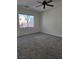 Bright bedroom with gray carpet, ceiling fan, and large window at 6460 Raven Hall St, North Las Vegas, NV 89084