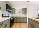 Modern kitchen featuring stainless steel appliances, gray cabinets, and a light wood flooring at 659 D Ave, Boulder City, NV 89005