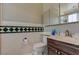 Clean bathroom with dark wood vanity, tiled shower, and decorative border at 7200 Big Rock Cir, Las Vegas, NV 89129