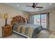 Main bedroom with wooden headboard, access to backyard patio, and ceiling fan at 7200 Big Rock Cir, Las Vegas, NV 89129