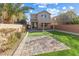 The landscaped backyard features artificial grass, stone pavers, and a pergola at 7516 Evening Melody Ct, Las Vegas, NV 89178