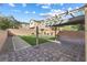 The backyard features grass, stone pavers and a shaded, wooden pergola at 7516 Evening Melody Ct, Las Vegas, NV 89178