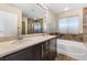 Bathroom featuring double sinks, stylish tile accents, and a soaking tub at 7516 Evening Melody Ct, Las Vegas, NV 89178