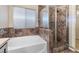 Luxurious bathroom showing a glass-enclosed shower and a modern soaking tub at 7516 Evening Melody Ct, Las Vegas, NV 89178